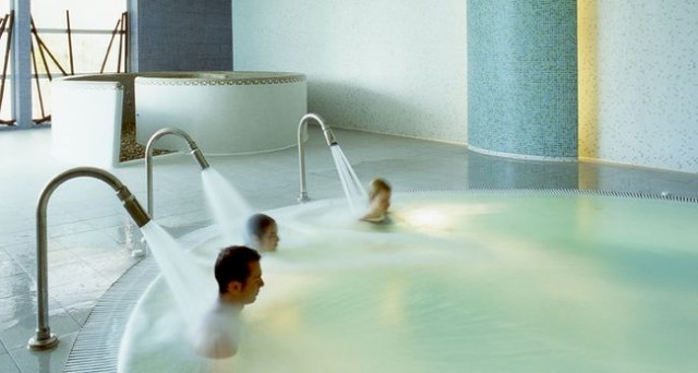 tres personas disfrutando de los chorros de agua en el spa en Madrid de Wellsport Club